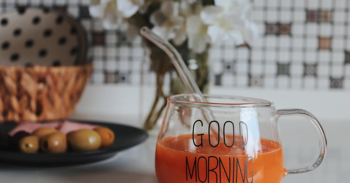 A refreshing orange juice in a clear 'Good Morning' cup on a table.